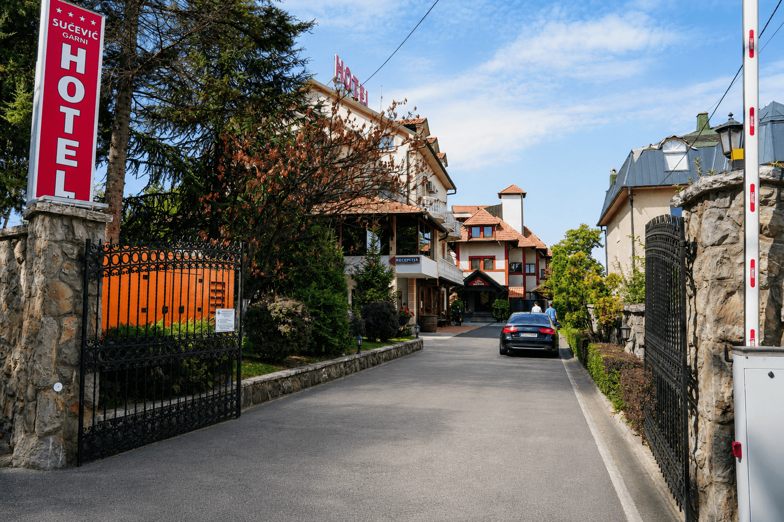Terasa hotela sa stolom za dvoje i pogledom na krovove i zelenilo
