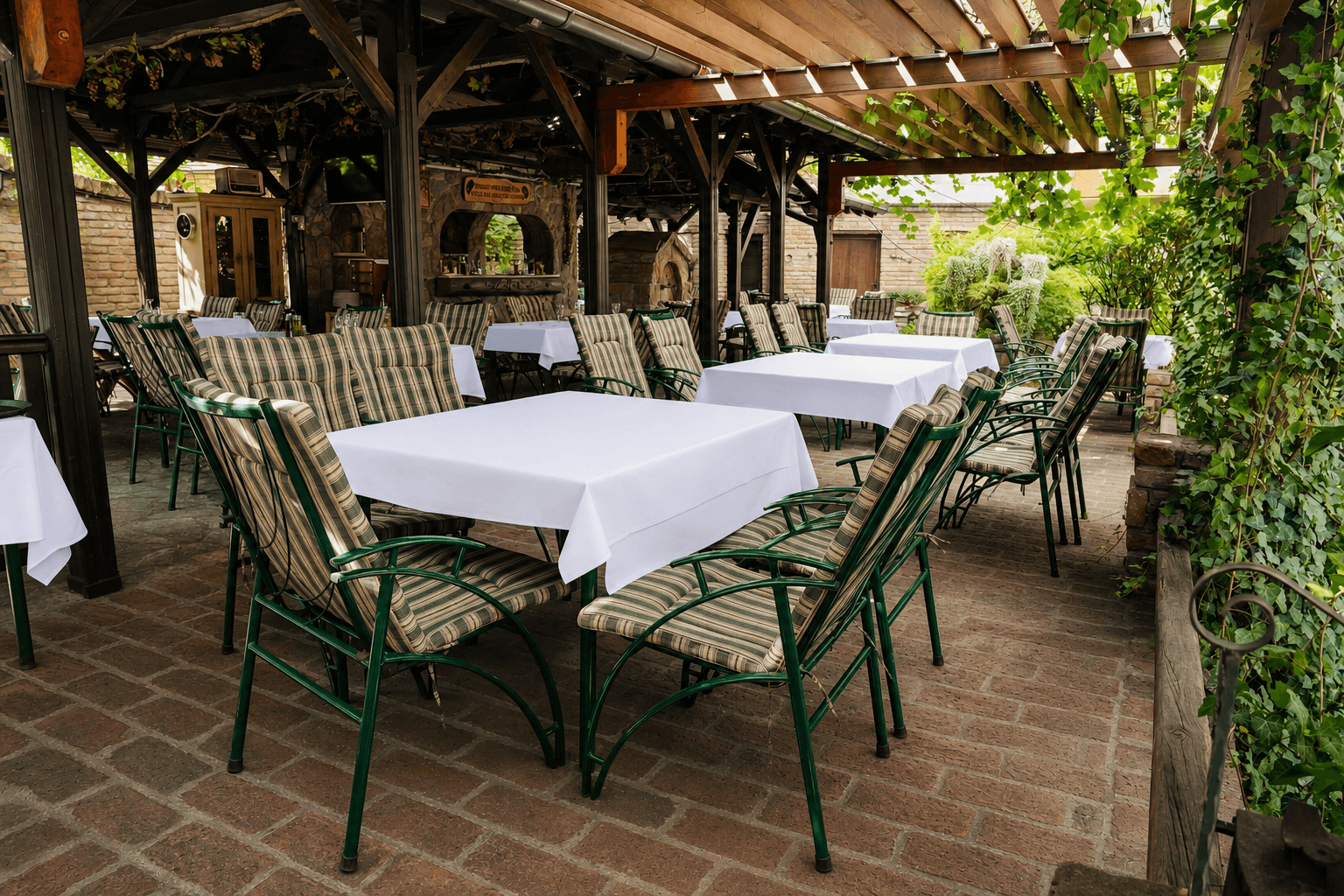 Letnja bašta sa stolovima, kamenom i zelenilom